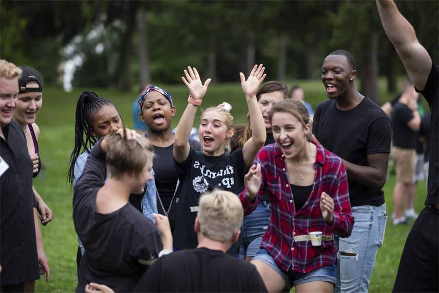 A group of students cheer together outdoors.